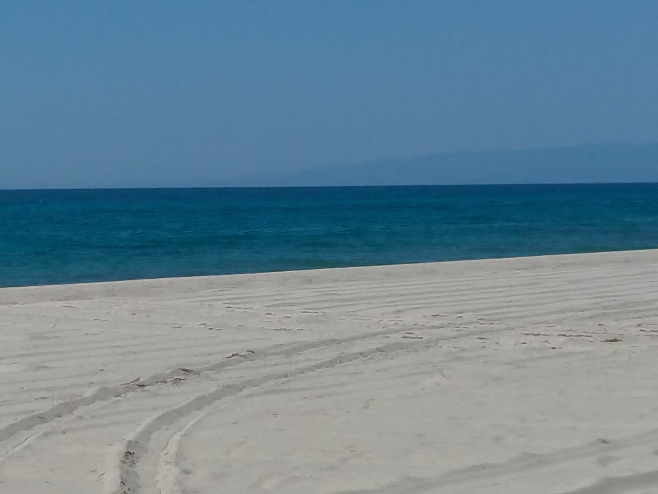 Il mare aperto incontra una distesa di sabbia chiara